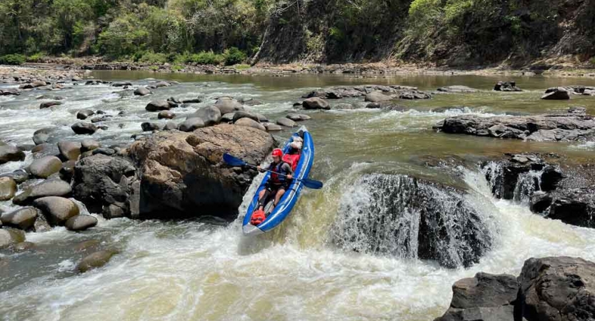 a person navigates a small waterfall in a watercraft on an outward bound expedition 